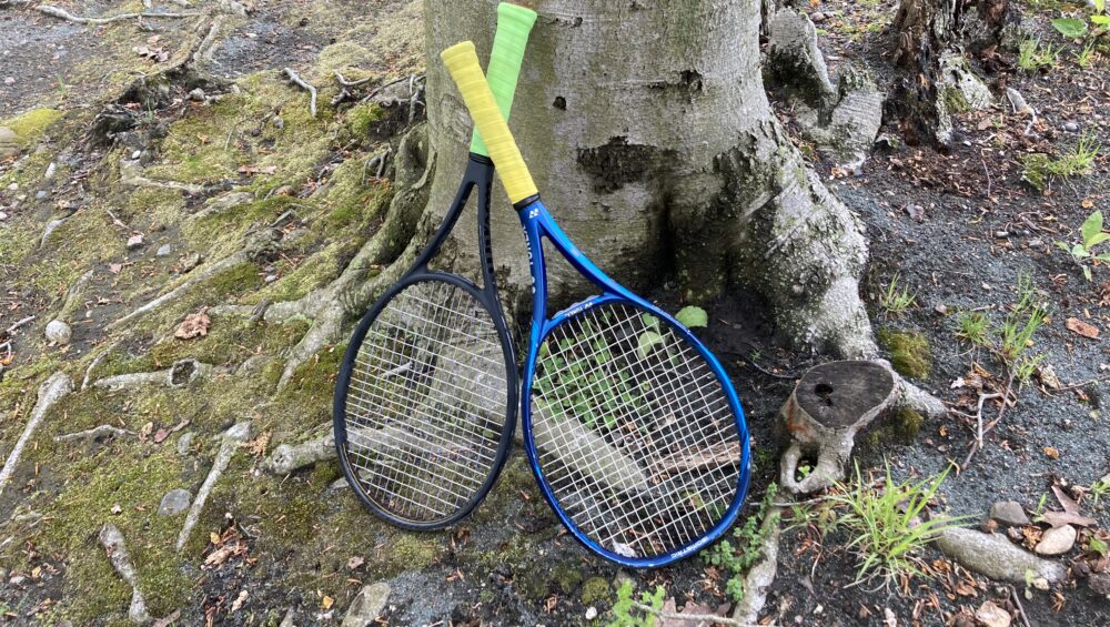 Two tennis rackets lean on a tree